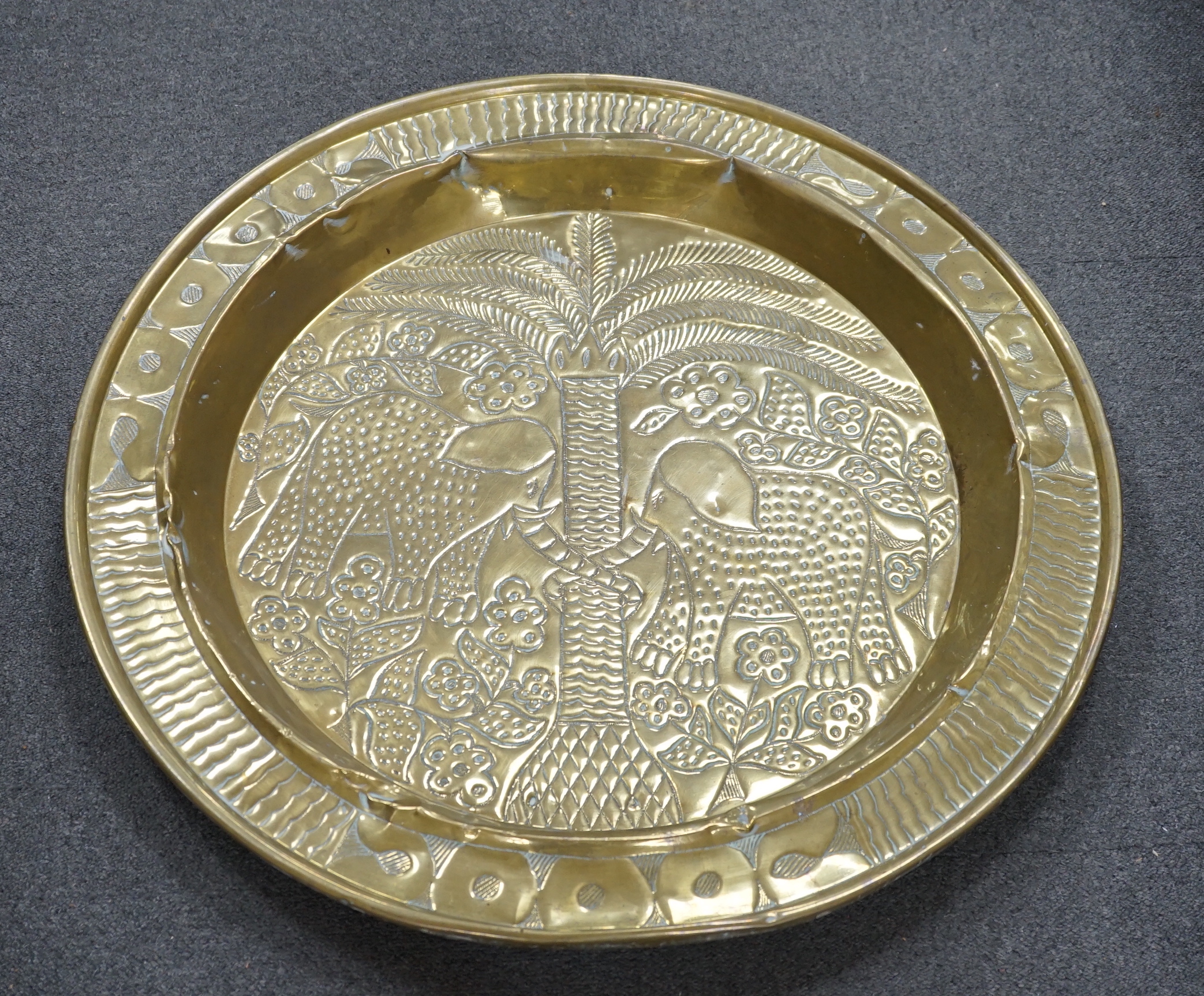 An embossed brass table top/ tray, 74cm diameter